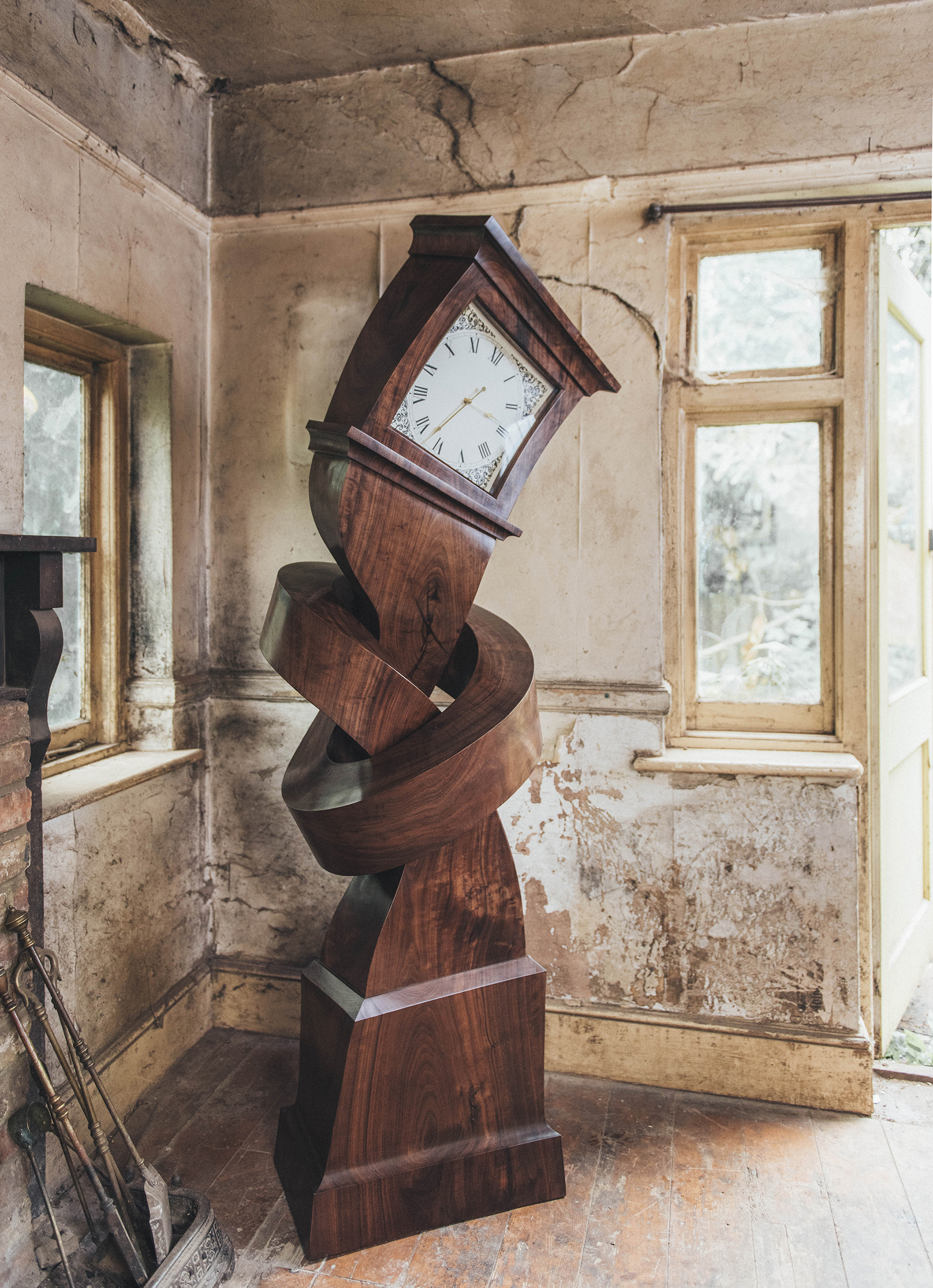 A wooden grandfather clock twisted into a spiral, photographed by Charles Emerson.